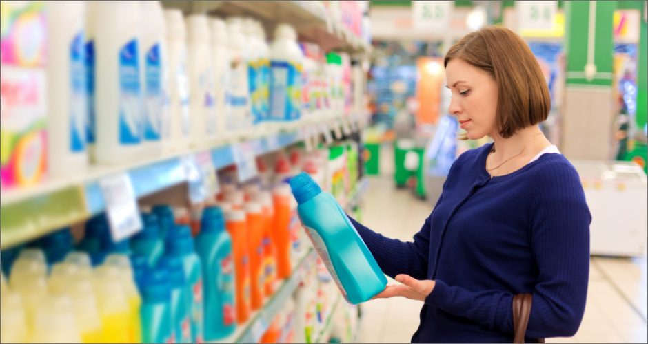 Woman in store holding blue detergent bottle