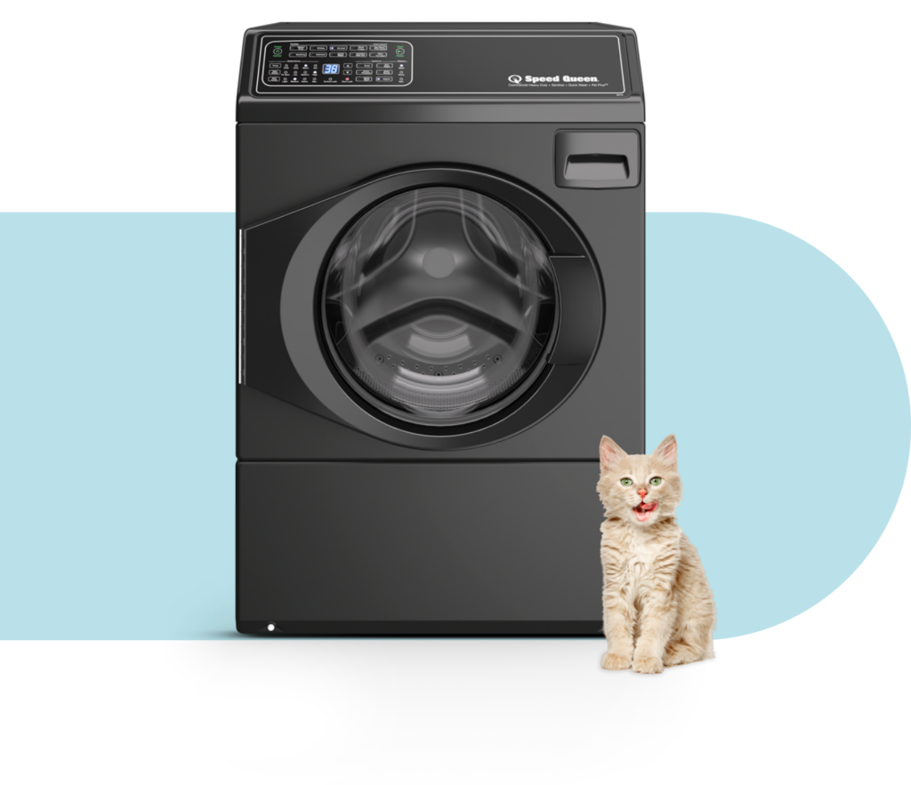 orange cat sitting in front of washer